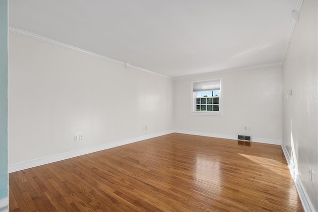 spare room with ornamental molding and hardwood / wood-style flooring