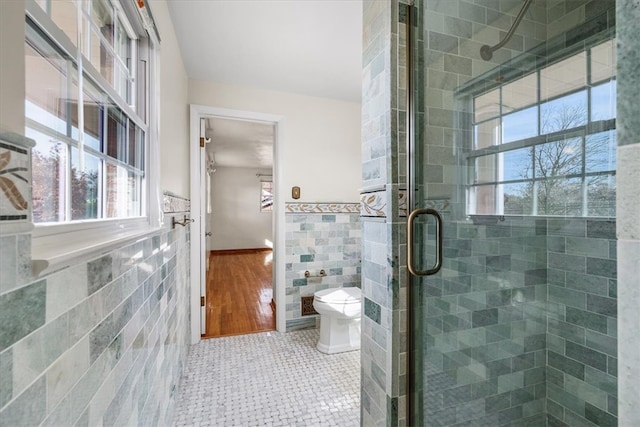 bathroom featuring toilet, tile walls, wood-type flooring, and an enclosed shower