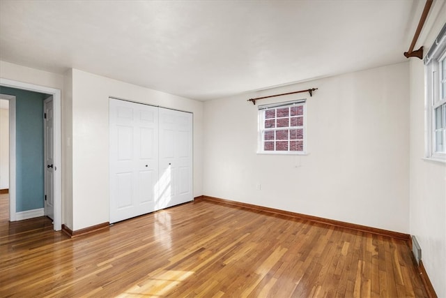 unfurnished bedroom with hardwood / wood-style floors and a closet