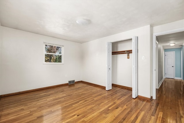 unfurnished bedroom featuring a closet and wood-type flooring