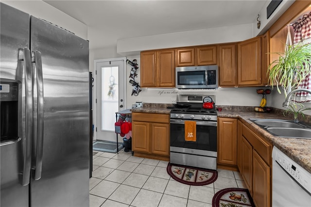 kitchen featuring light tile patterned flooring, sink, and appliances with stainless steel finishes