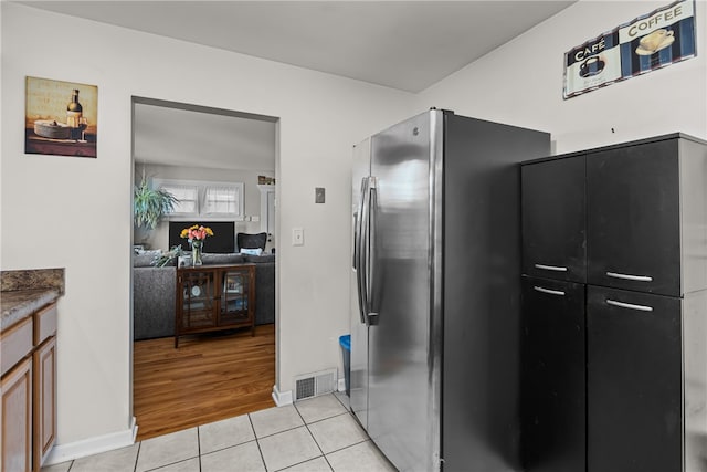 kitchen with light hardwood / wood-style flooring and stainless steel refrigerator