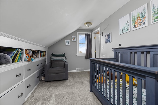 bedroom featuring a nursery area, light colored carpet, and lofted ceiling