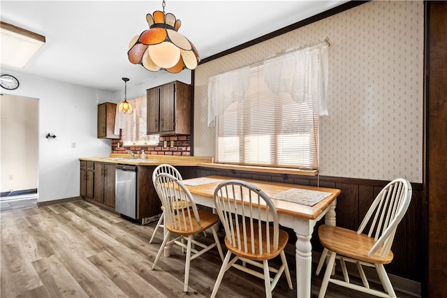 dining room featuring ornamental molding, light hardwood / wood-style flooring, and sink