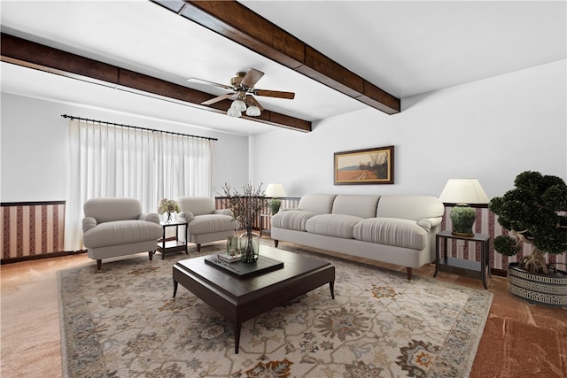 living room featuring beamed ceiling, ceiling fan, and carpet