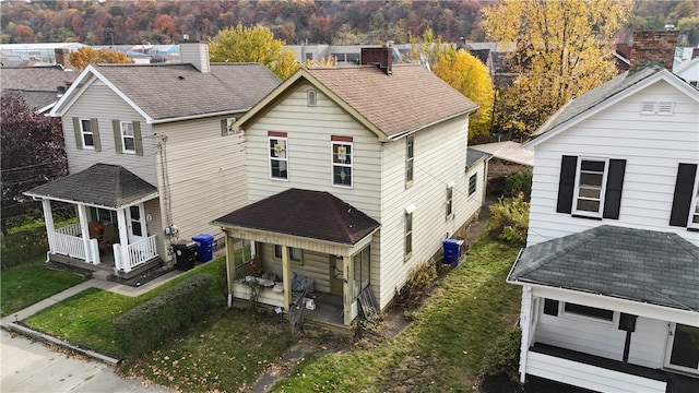 rear view of house featuring a porch, central AC unit, and a garage