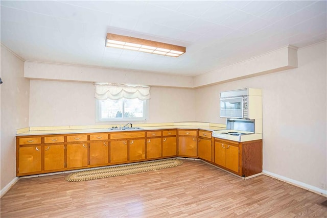 79-81 Lower Clinton St, Canoe/Banks Twps, PA 15772 - kitchen with light wood-type flooring, light countertops, brown cabinets, stainless steel microwave, and ornamental molding