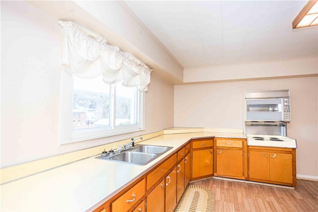 79-81 Lower Clinton St, Canoe/Banks Twps, PA 15772 - kitchen with a sink, light countertops, white microwave, light wood-style flooring, and brown cabinetry
