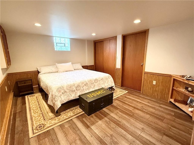 bedroom with wood-type flooring and wood walls