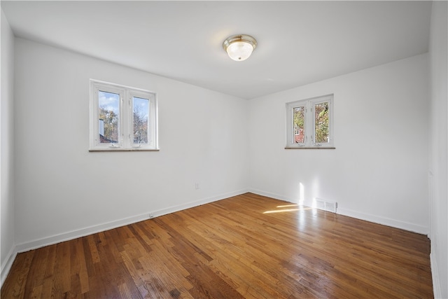 unfurnished room with hardwood / wood-style flooring