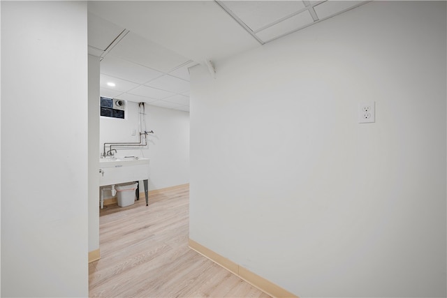 hallway featuring light hardwood / wood-style flooring and a drop ceiling