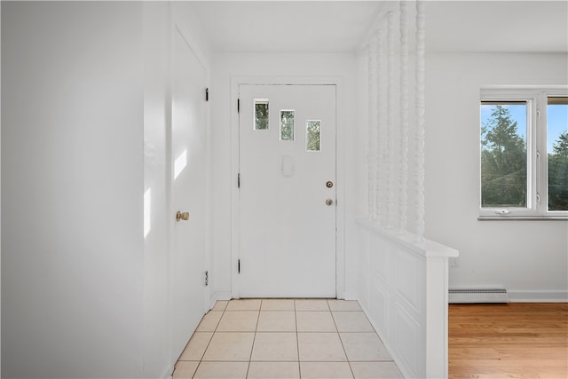 doorway with a wealth of natural light, light hardwood / wood-style flooring, and baseboard heating