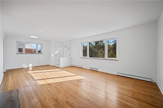 unfurnished living room with a baseboard radiator and light hardwood / wood-style floors