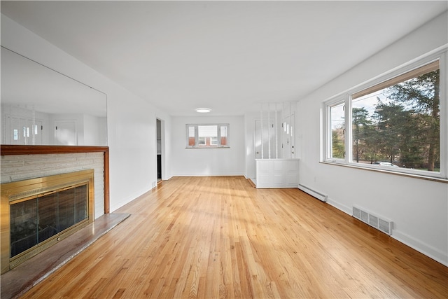 unfurnished living room featuring a baseboard radiator and light hardwood / wood-style flooring