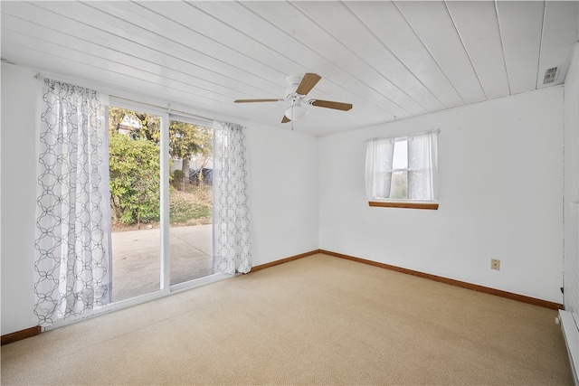 carpeted spare room featuring a baseboard heating unit, ceiling fan, and wooden ceiling