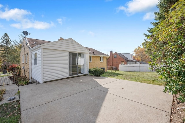 rear view of house featuring a patio and a lawn