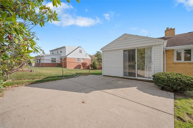 rear view of house with a patio and a lawn