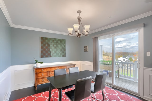 dining space with an inviting chandelier, ornamental molding, and dark wood-type flooring