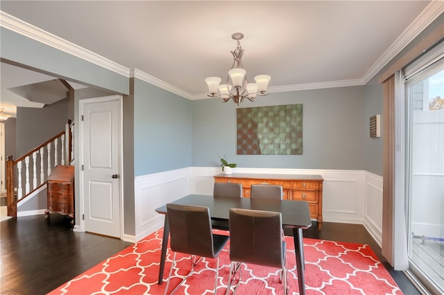 dining area with ornamental molding, dark wood-type flooring, and a notable chandelier