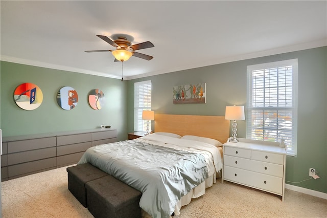 bedroom with ceiling fan, crown molding, and light colored carpet