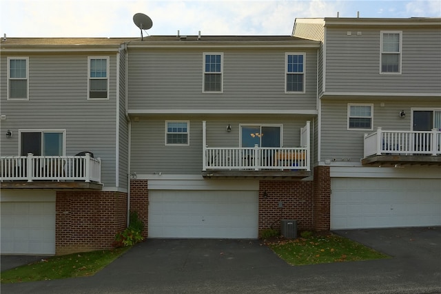 back of house featuring cooling unit, a balcony, and a garage