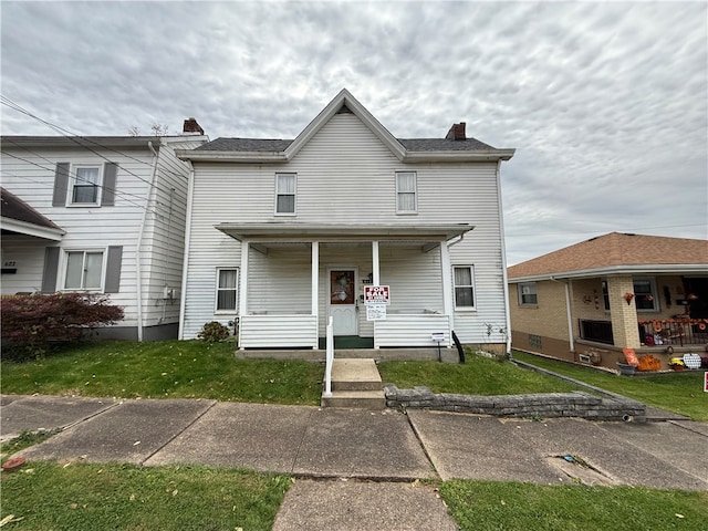 view of front facade with covered porch and a front yard