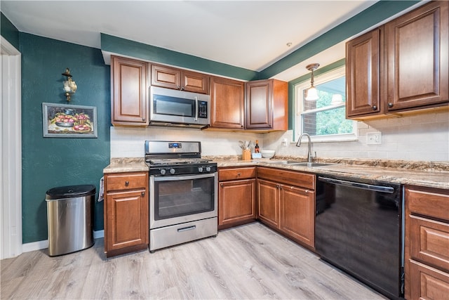 kitchen with sink, decorative backsplash, stainless steel appliances, and light hardwood / wood-style floors