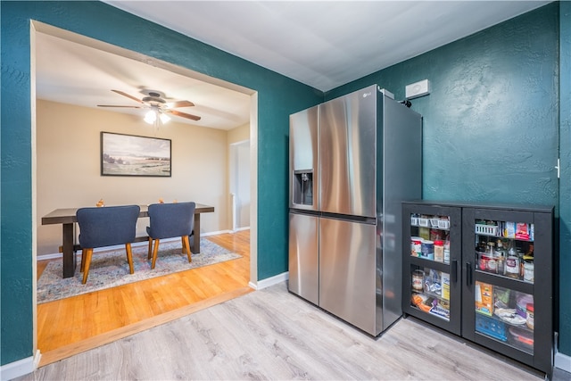 kitchen featuring ceiling fan, wood-type flooring, and stainless steel refrigerator with ice dispenser