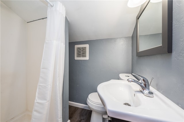 bathroom featuring toilet, hardwood / wood-style floors, sink, vaulted ceiling, and curtained shower