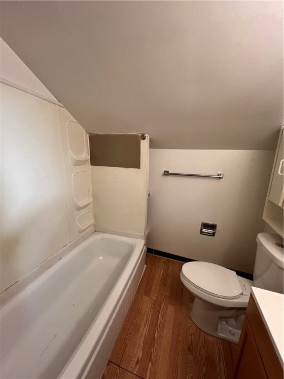 bathroom with vanity, a tub, wood-type flooring, and toilet