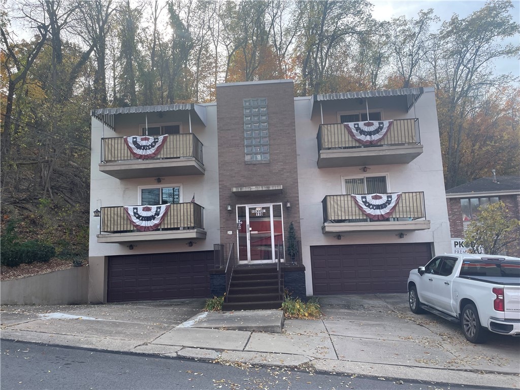 multi unit property with a garage and a balcony