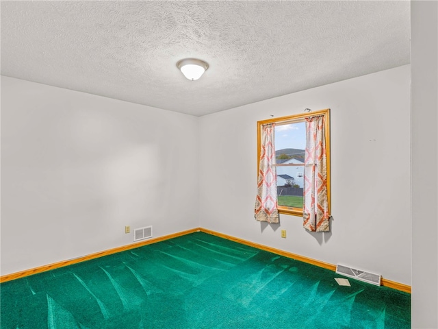 unfurnished room with a textured ceiling and carpet floors