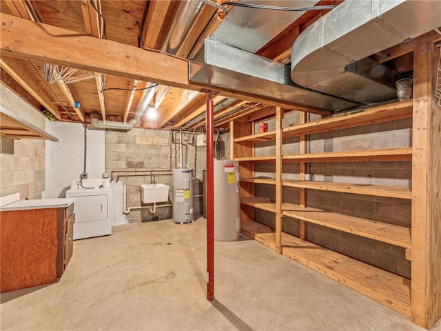 basement with sink, gas water heater, washing machine and clothes dryer, and water heater