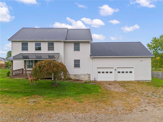 rear view of house featuring a lawn and a garage