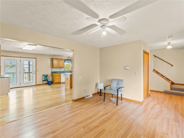 unfurnished room with light hardwood / wood-style floors, a textured ceiling, and ceiling fan