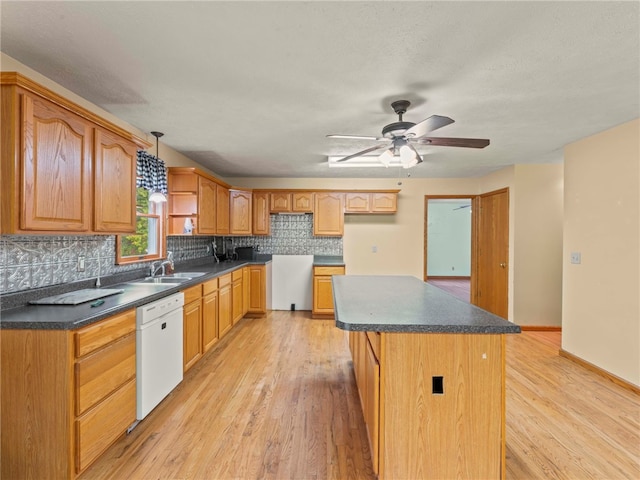 kitchen with dishwasher, decorative backsplash, a center island, decorative light fixtures, and light hardwood / wood-style floors