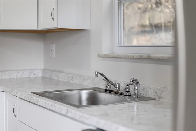 kitchen featuring white cabinets and sink