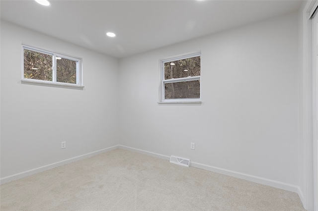 spare room featuring light colored carpet