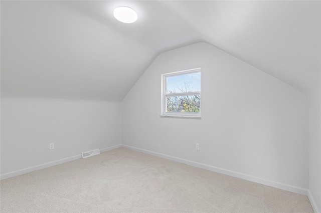 additional living space with carpet floors and vaulted ceiling