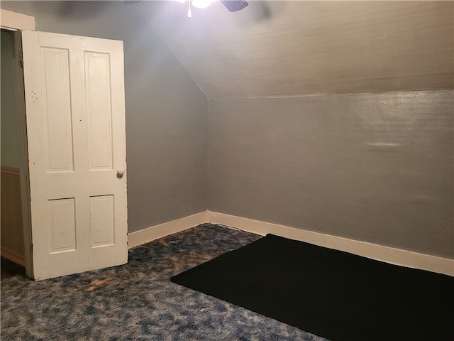 additional living space featuring ceiling fan, lofted ceiling, and dark colored carpet