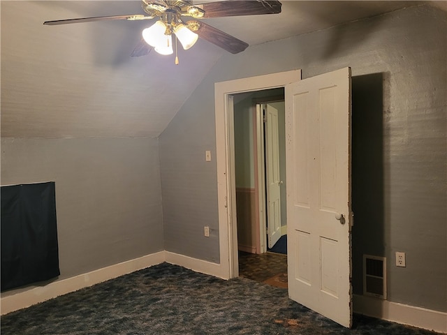 additional living space featuring lofted ceiling, dark carpet, and ceiling fan