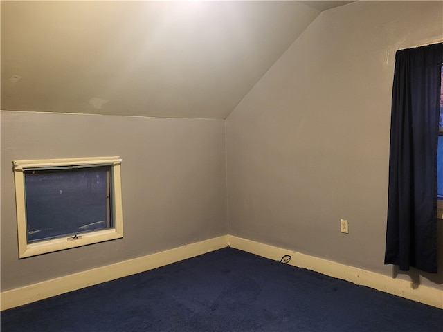 bonus room featuring lofted ceiling and dark carpet