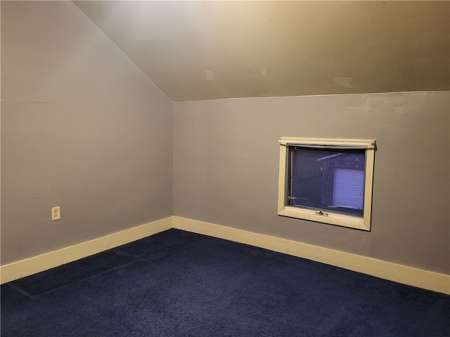 spare room featuring vaulted ceiling and carpet floors