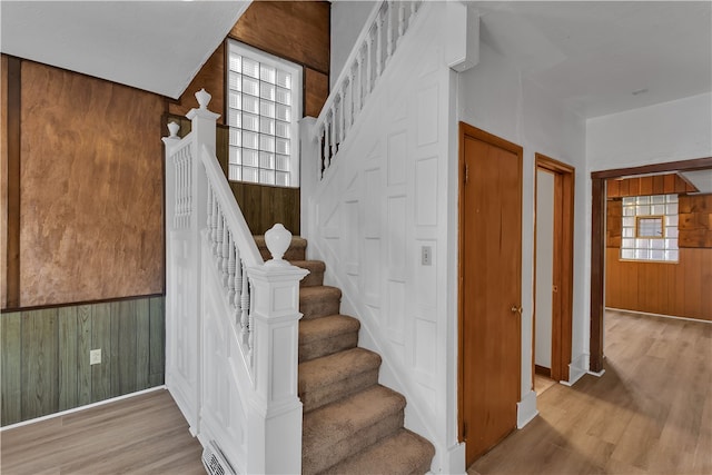 staircase with wood walls and hardwood / wood-style floors