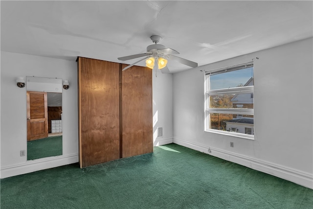 unfurnished bedroom with a closet, dark carpet, and ceiling fan