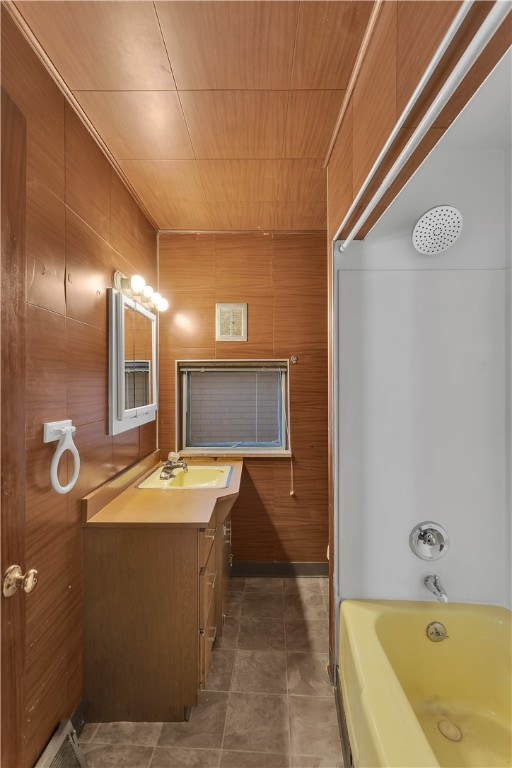 bathroom featuring vanity, wood walls, and tile patterned flooring