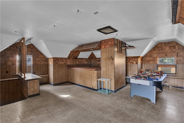 game room with cooling unit, lofted ceiling, and wooden walls