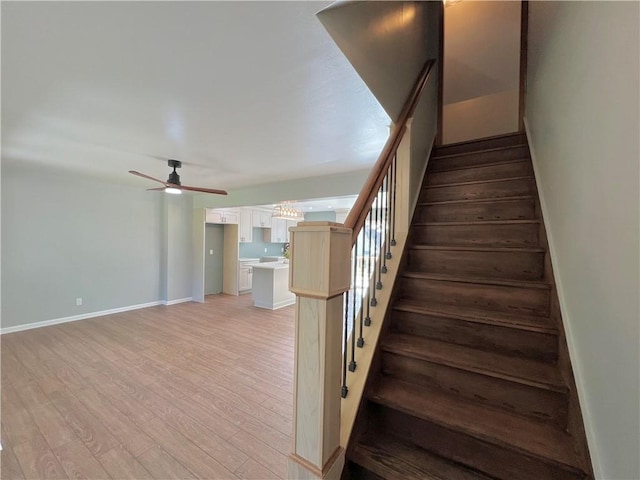 staircase featuring hardwood / wood-style flooring and ceiling fan