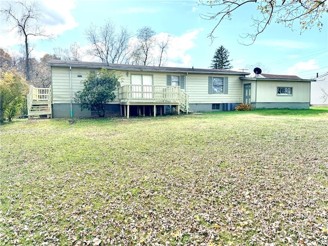 back of house with a wooden deck and a lawn