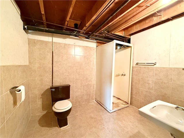 bathroom with toilet and tile walls